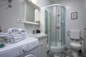 a white bathroom with a shower and a washing machine at Agostini Residence - SELF CHECK-IN ONLY in Rijeka +57 photos