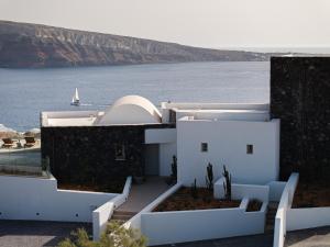 a white house with a view of the water at The Villas by Santo Collection in Oia