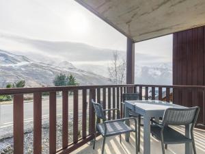 une table et des chaises sur un balcon avec des montagnes dans l'établissement Peyragudes : Appart 8 pers, balcon, parking, wifi - FR-1-695-51, à Germ