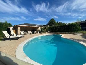 ein großer blauer Swimmingpool vor einem Haus in der Unterkunft Chambre d'hôtes avec piscine et petit-déjeuner proche d'Angers - FR-1-622-84 in La Rochefoulques