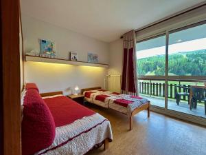 a hotel room with two beds and a balcony at Appartement pour 8 pers. à 50m des pistes avec Wifi et Parking - FR-1-525-288 in Superdevoluy