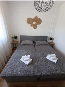 モスタルにあるLuna APARTMANIのベッドとタオル2枚のある寝室