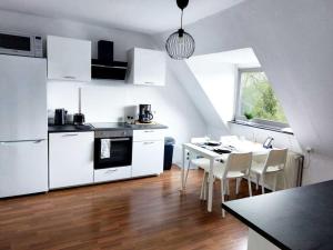 a kitchen with white appliances and a table and chairs at Cozy apartment with Garden in Gelsenkirchen in Gelsenkirchen