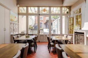 a restaurant with tables and chairs and a fireplace at Luxueus vakantiehuis in hartje Ronse met 7 slaapkamers & badkamers in Ronse