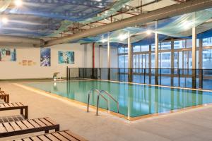 a swimming pool in a large building with a large window at Questa Thermal & Spa Hotel in Eskisehir