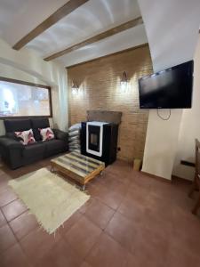 a living room with a couch and a fireplace at Casa Rural El Molino in Macastre