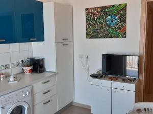cocina con lavadora y TV en Casa sul mare, en Realmonte