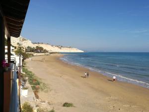 Una playa con gente caminando sobre la arena y el océano. en Casa sul mare, en Realmonte 9 fotos más