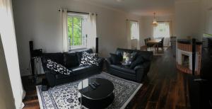 a living room with a black couch and a table at House by the ocean in Mariehamn in Mariehamn