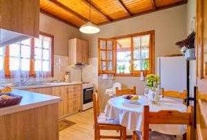 a kitchen with a table and a refrigerator at Kodelo summer house in Corfu