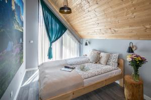 Łóżko w pokoju z drewnianym sufitem w obiekcie Góralski Dom - Widokowa Osada Gawlaki Zakopane - Loft Affair w Zakopanem