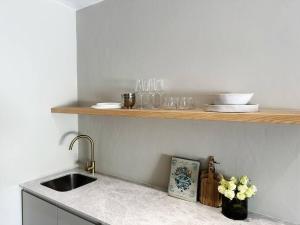 a kitchen with a sink and a counter with flowers at Stellenbosch Winelands Apartment in Stellenbosch