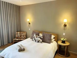 a bedroom with a white bed with pillows on it at Stellenbosch Winelands Apartment in Stellenbosch