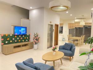 Royal Lotus Hạ Long Resort & Villas في ها لونغ: غرفة معيشة مع تلفزيون بشاشة مسطحة وأثاث