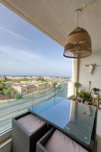 a glass table in a room with a large window at A Stunning 3BR Home with private terrace in Swieqi by 360 Estates in Is-Swieqi