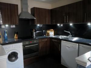 cocina con fregadero y lavadora en Edinburgh Old Town Apartment, en Edimburgo