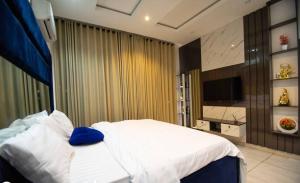 a bedroom with a bed with a blue pillow on it at 3bedroom luxury apartment with pool, snooker, ps5 in lekki phase 1 in Lekki +1 photo
