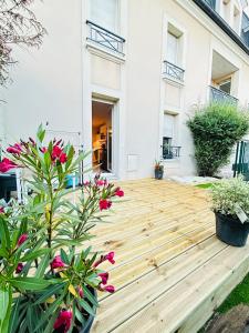 a wooden deck in front of a house with flowers at Logement entier proche de Paris in Croissy-sur-Seine