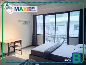 a bedroom with a bed and a desk and a balcony at MAXi MaMa House in Bangkok