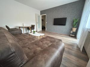 ein Wohnzimmer mit einem braunen Sofa und einem Tisch in der Unterkunft Apartment Lori in Mönchengladbach