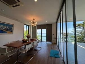 a dining room with a long table and chairs at 4bedroom Villa Siray Beach Front in Phuket Town