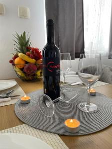 a bottle of wine sitting on a table with glasses at Apartman Naturalis flumen in Otočac +23 photos
