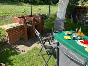 a table and chairs in a backyard with a grill at Ferienwohnung Winzenburg Naturnah und ruhig gelegene Ferienwohnung nah am Steinhuder Meer und Dino Park Münchehagen in Rehburg-Loccum