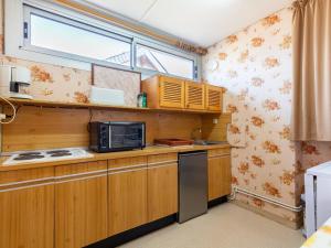 une cuisine avec des armoires en bois et un micro-ondes dans l'établissement Studio 6 pers. Peyragudes, proche pistes, navette, parking - FR-1-695-57, à Gouaux-de-Larboust 3 autres photos