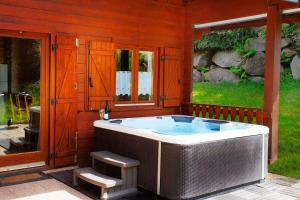 a jacuzzi tub in a house with a window at Chalet Les Brimbelles avec Jacuzzi in Gérardmer +24 photos