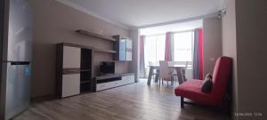 a living room with a red chair and a television at Apartamentos Green Park Tenerife in San Miguel de Abona