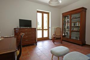 a living room with a tv and a dresser with a tvicterictericter at Villa La Punta in Bellagio