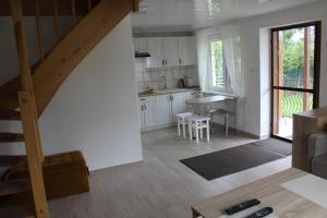 a kitchen with white cabinets and a staircase in a house at Dom letniskowy - do 10 osób in Dźwirzyno