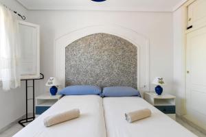 een witte slaapkamer met 2 bedden en blauwe kussens bij HE La Florida-David in Orihuela-Costa +3 foto's