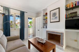 een woonkamer met open haard en tv bij HE La Florida-David in Orihuela-Costa