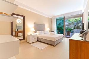a large bedroom with a bed and a mirror at The Residence Aparthotel in Podstrana