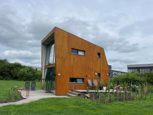 a wooden building with windows on top of a field at Casitas Wijchen in Wijchen +10 photos