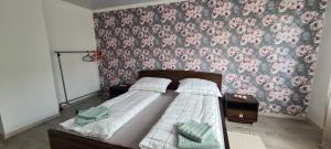 ein Schlafzimmer mit einem Bett mit floraler Tapete in der Unterkunft Jarocin in Jarocin