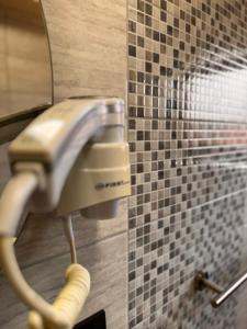 a blow dryer in a bathroom with a tile wall at Villa Aroma 2 in Orašje +289 photos