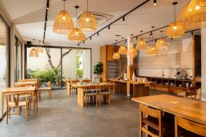 a restaurant with wooden tables and chairs and chandeliers at Eden Resort & Villas Phuket Patong in Patong Beach