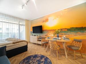 a bedroom with a bed and a table and a television at Apartament Morski Spokój Solny Resort in Kołobrzeg