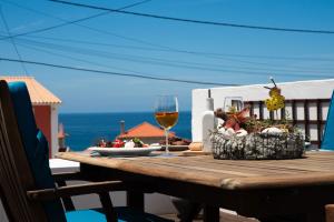 a wooden table with a glass of wine and food at Chez Nous in Sintra