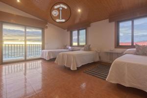 a room with three beds and a clock on the wall at casa picota in Oia