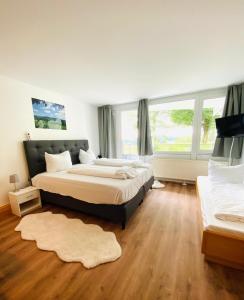 a bedroom with two beds and a large window at Ferienwohnung Schönblick in Sankt Englmar