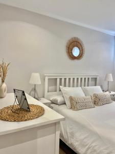 a white bedroom with two beds and a laptop on a table at Villa Paraíso - Piscina Playa Barbacoa Wifi in San Juan de Alicante