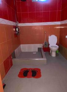 a bathroom with a toilet and a red tiled wall at Amaizing home stay 7 in Dar es Salaam +12 photos