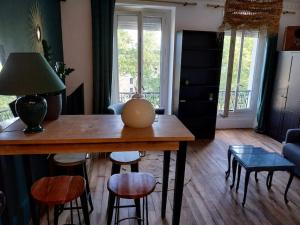 a living room with a wooden table and chairs at Bel Apt châteaux de Vincennes in Vincennes