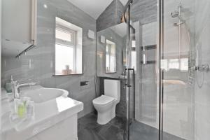 a bathroom with a toilet and a sink and a shower at 3 Bedroom Bungalow Sunningdale Lodge Ascot Races in Sunningdale +17 photos