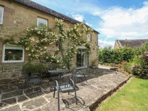 a patio with chairs and a table in front of a building at Dale View Cottage in Bakewell