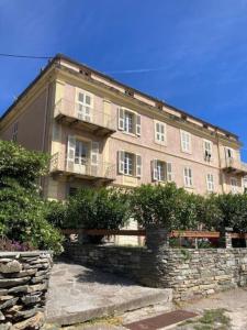 a large brick building with a stone wall at Maison d Americain a Figarella au Cap Corse in Santa-Maria-di-Lota