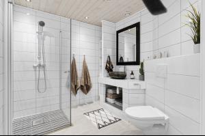 a white bathroom with a shower and a toilet at Rekkehus sentralt i Stavanger - nære ONS messen in Stavanger +8 photos